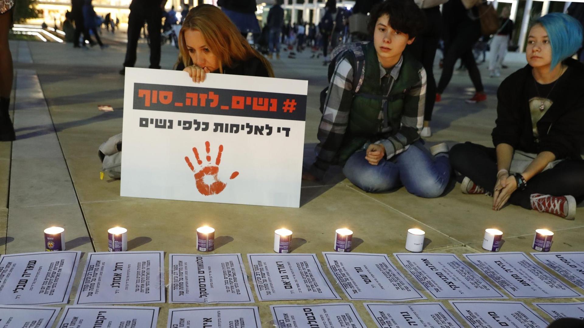 Eine israelische Frau hält ein Schild in der Hand mit der Aufschrift "Stopt die Gewalt gegen Frauen".