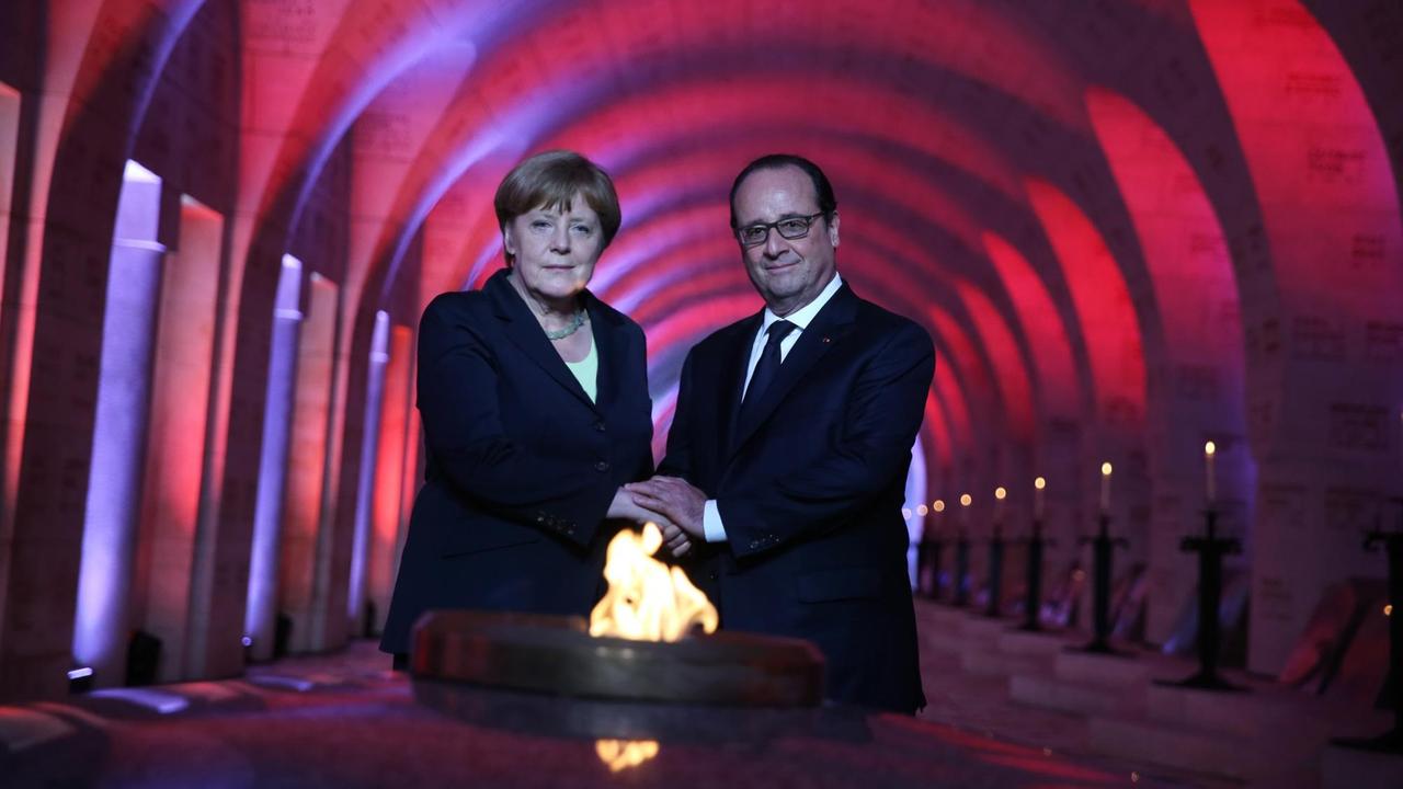 Bundeskanzlerin Angela Merkel und Frankreichs Präsident François Hollande beim Anzünden der "Flamme der Erinnerung" im Gedenken an die Schlacht von Verdun.