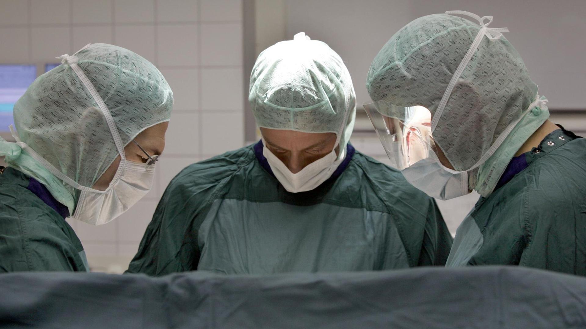 Ein OP-Team, bestehend aus drei Personen, operieren