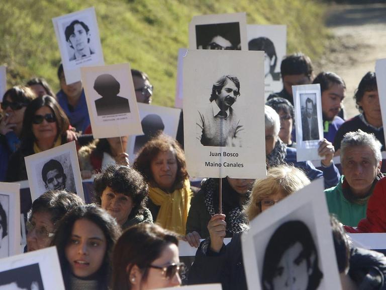 Angehörige von Colonia Dignidad-Opfern halten 2016 Schilder mit Fotos hoch