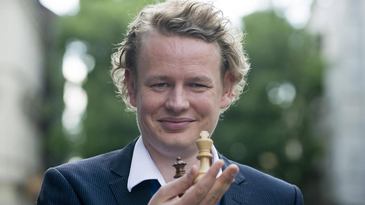 Der Blitzschachmeister Jan Gustavsson hält Spielsteine in der Hand
