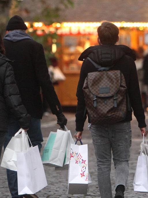 Am zweiten Adventssamstag tragen Passanten Papiertüten mit Einkäufen in der Innenstadt von Frankfurt, Hessen, Deutschland