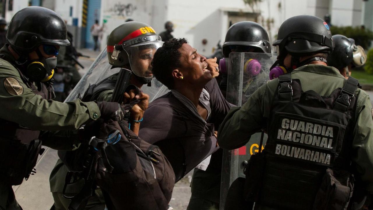 Polizisten nehmen einen Demonstranten in Caracas am Rande von Protesten gegen Präsident Maduro fest.