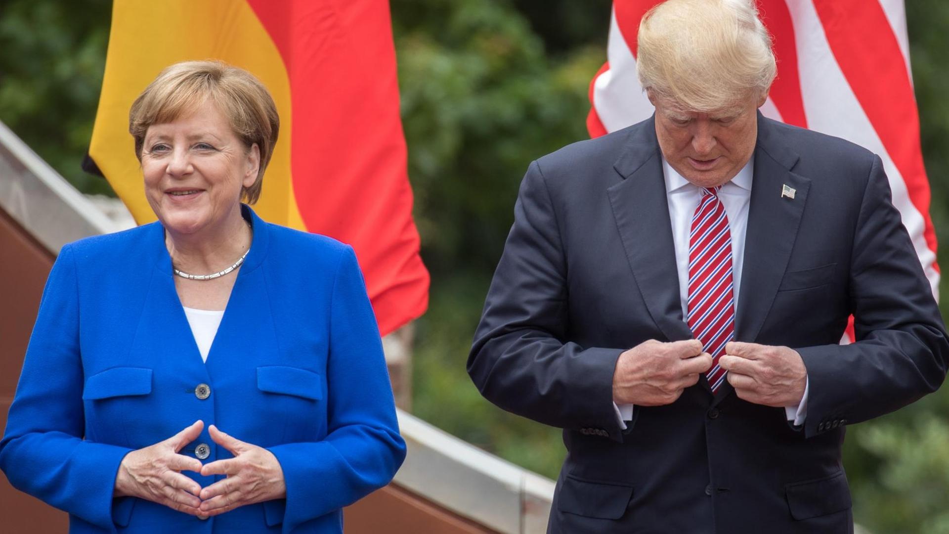 ARCHIV - Bundeskanzlerin Angela Merkel steht neben US-Präsident Donald Trump, der sich noch kurz sein Jackett richtet, 26.05.2017 beim Familienfoto beim G7-Gipfel in Taormina in Italien. ARCHIV - Bundeskanzlerin Angela Merkel steht neben US-Präsident Donald Trump, der sich noch kurz sein Jackett richtet, 26.05.2017 beim Familienfoto beim G7-Gipfel in Taormina in Italien.