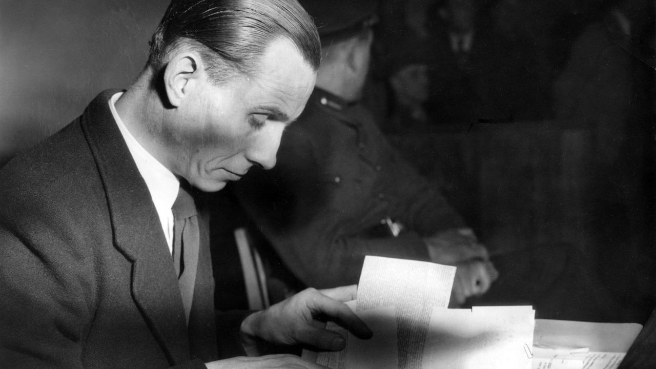 Otto Ernst Remer liest vor dem Landgericht Braunschweig in seinen Unterlagen. Er hatte die Beteiligten des Attentats auf Hitler als "Landesverräter" bezeichnet.Er war an der Niederschlagung des Umsturzversuchs nach dem Attentat auf Hitler am 20.07.1944 beteiligt. 