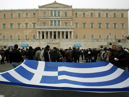 Demonstranten halten vor dem griechischen Parlament in Athen die griechische Flagge hoch. Ein zweitägiger landesweiter Streik gegen die Sparmaßnahmen der Regierung legt das Land derzeit lahm.