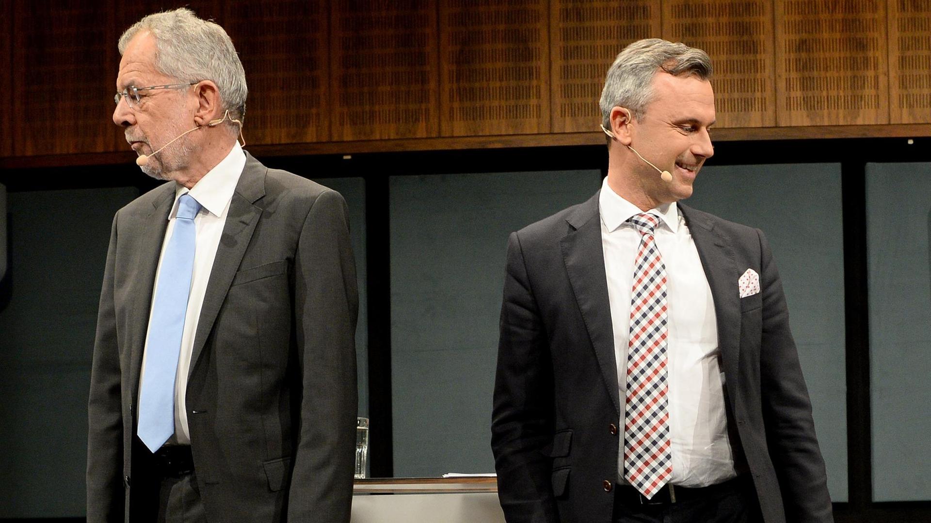 Der FPÖ-Kandidaten Norbert Hofer und der von den Grünen unterstützte Alexander Van der Bellen stehen voneinander abgewandt in der TV-Debatte nebeneinander.
