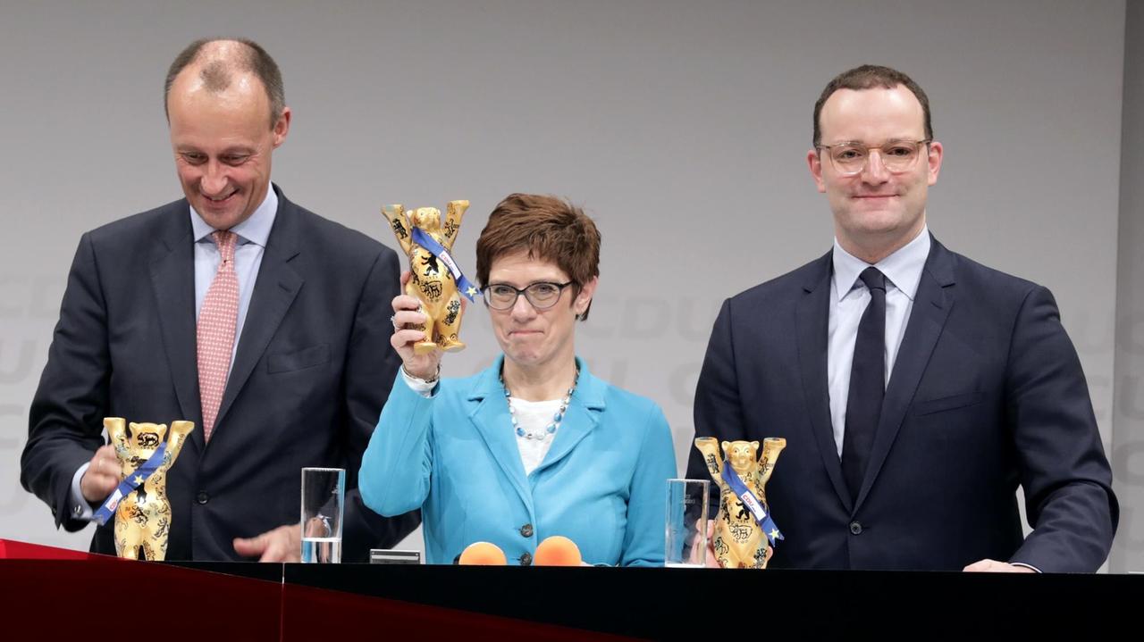 Die drei Kandidaten für den CDU-Bundesvorsitz, Friedrich Merz (CDU, links), früherer Unions-Fraktionschef, Annegret Kramp-Karrenbauer, CDU-Generalsekretärin, und Jens Spahn (CDU), Bundesminister für Gesundheit, bekommen bei der CDU-Regionalkonferenz Berlin/Brandenburg Bären als Geschenk.