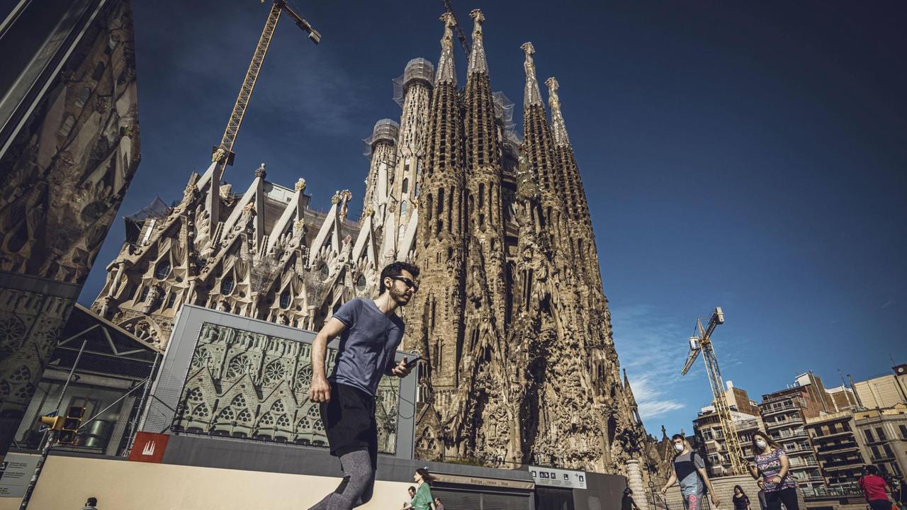 Sportler und Menschen Anfang Mai an der Basilika "Sagrada Família" in Barcelona.