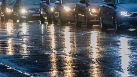 Autos stehen am Morgen im Berufsverkehr im Regen an einer Ampel.