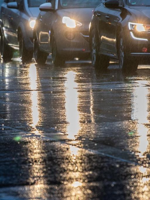 Autos stehen am Morgen im Berufsverkehr im Regen an einer Ampel.