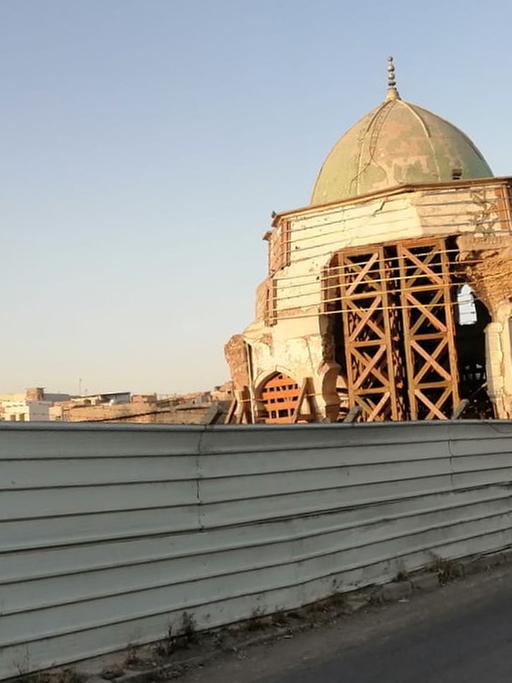 Die Nouri Moschee in Mossul mit Gerüst und Bauzaun.