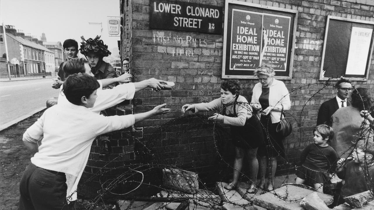 Menschen werfen sich Brot zu; aus einer Reportage über Unruhen in Nordirland, 1969.