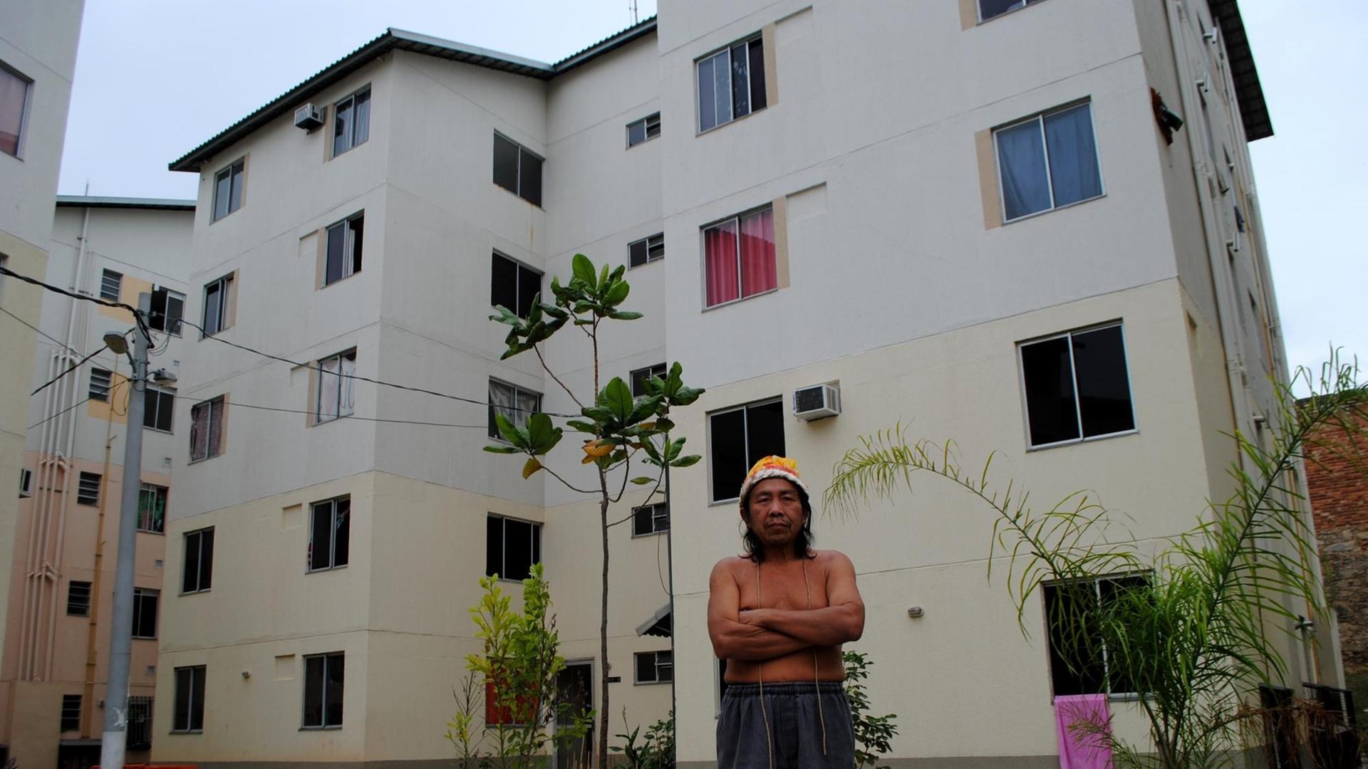 Carlos Turkano steht mit verschränkten Armen vor dem Wohnblock.