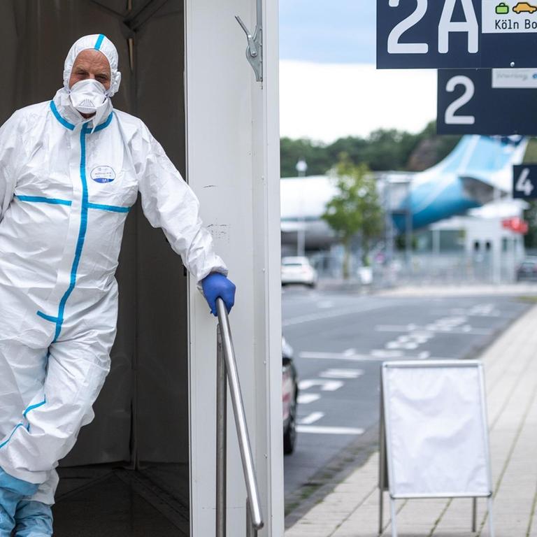 Ein Mitarbeiter des Corona-Testzentrum am Flughafen Köln/Bonn steht im Eingang des Testzentrums.