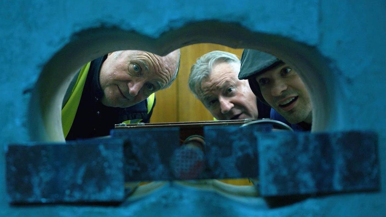 Drei alte Männer gucken durch ein gesprengtes Loch
