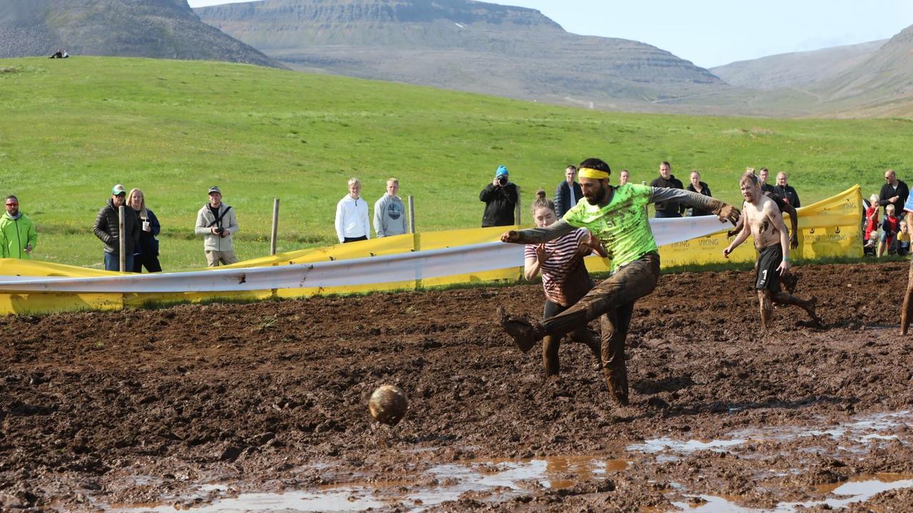 Ein Teilnehmer der Schlammfußball-EM in Island schießt den Ball