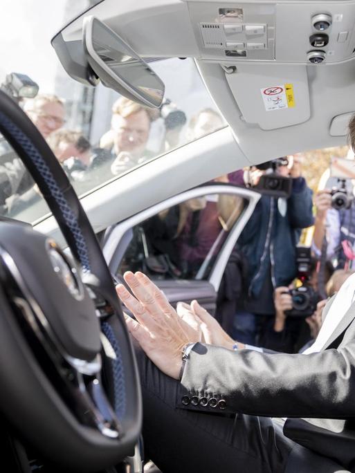 Andreas Scheuer (CSU), Bundesverkehrsminister, sitzt bei einer Veranstaltung zur Eröffnung eines Testfelds für automatisiertes und vernetztes Fahren in Berlin auf dem Beifahrersitz in einem automatisierten Fahrzeug. Auf dem Fahrersitz sitzt niemand, Scheuer greift in die Luft, als fasse er ein Lenkrad an.