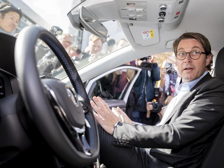 Andreas Scheuer (CSU), Bundesverkehrsminister, sitzt bei einer Veranstaltung zur Eröffnung eines Testfelds für automatisiertes und vernetztes Fahren in Berlin auf dem Beifahrersitz in einem automatisierten Fahrzeug. Auf dem Fahrersitz sitzt niemand, Scheuer greift in die Luft, als fasse er ein Lenkrad an.