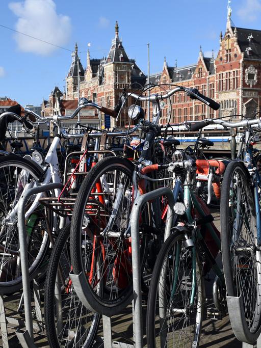 Fahrräder stehen vor dem Haupteingang des Bahnhofs Amsterdam Central (aufgenommen 2015)
