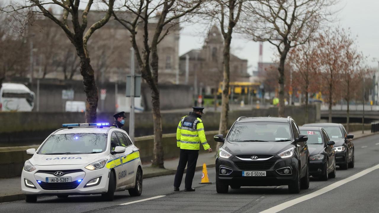 Irland, Dublin: Ein Polizist hält Autofahrer an einem Kontrollpunkt an den Quays im Stadtzentrum an, während Irland sich in einem Corona-Lockdown befindet.