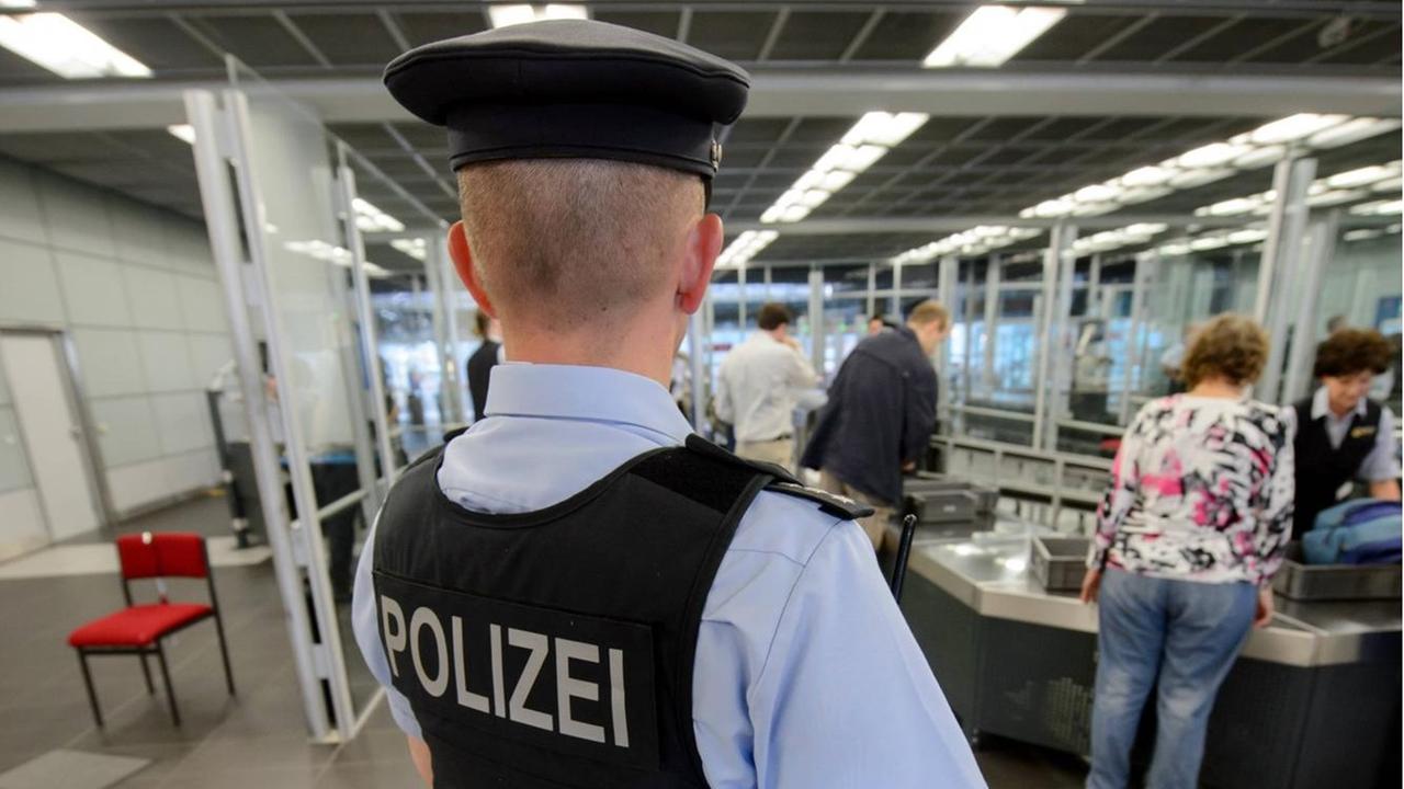 Ein Beamter der Bundespolizei steht am Flughafen Dresden International im Bereich des Check-In bei der Gepäckkontrolle.