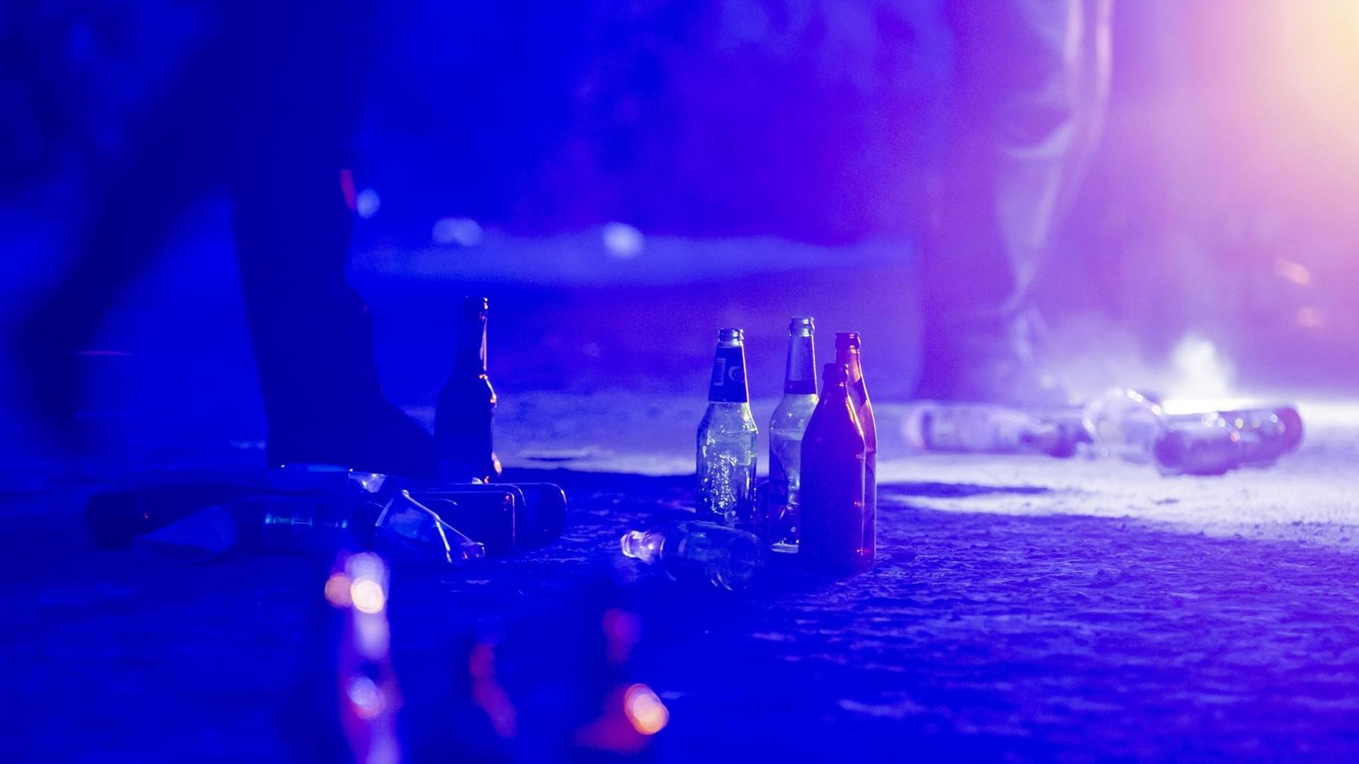 Bierflaschen stehen auf dem Boden, nachdem die Polizei eine illegale Party in der Berliner Hasenheide aufgelöst hat.