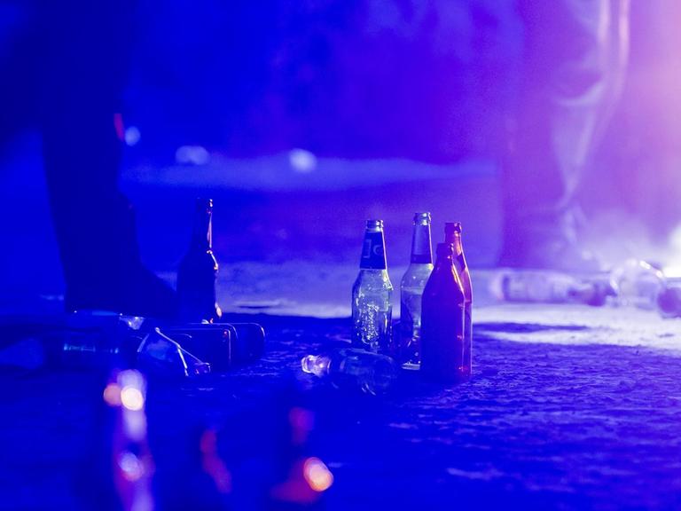 Bierflaschen stehen auf dem Boden, nachdem die Polizei eine illegale Party in der Berliner Hasenheide aufgelöst hat.