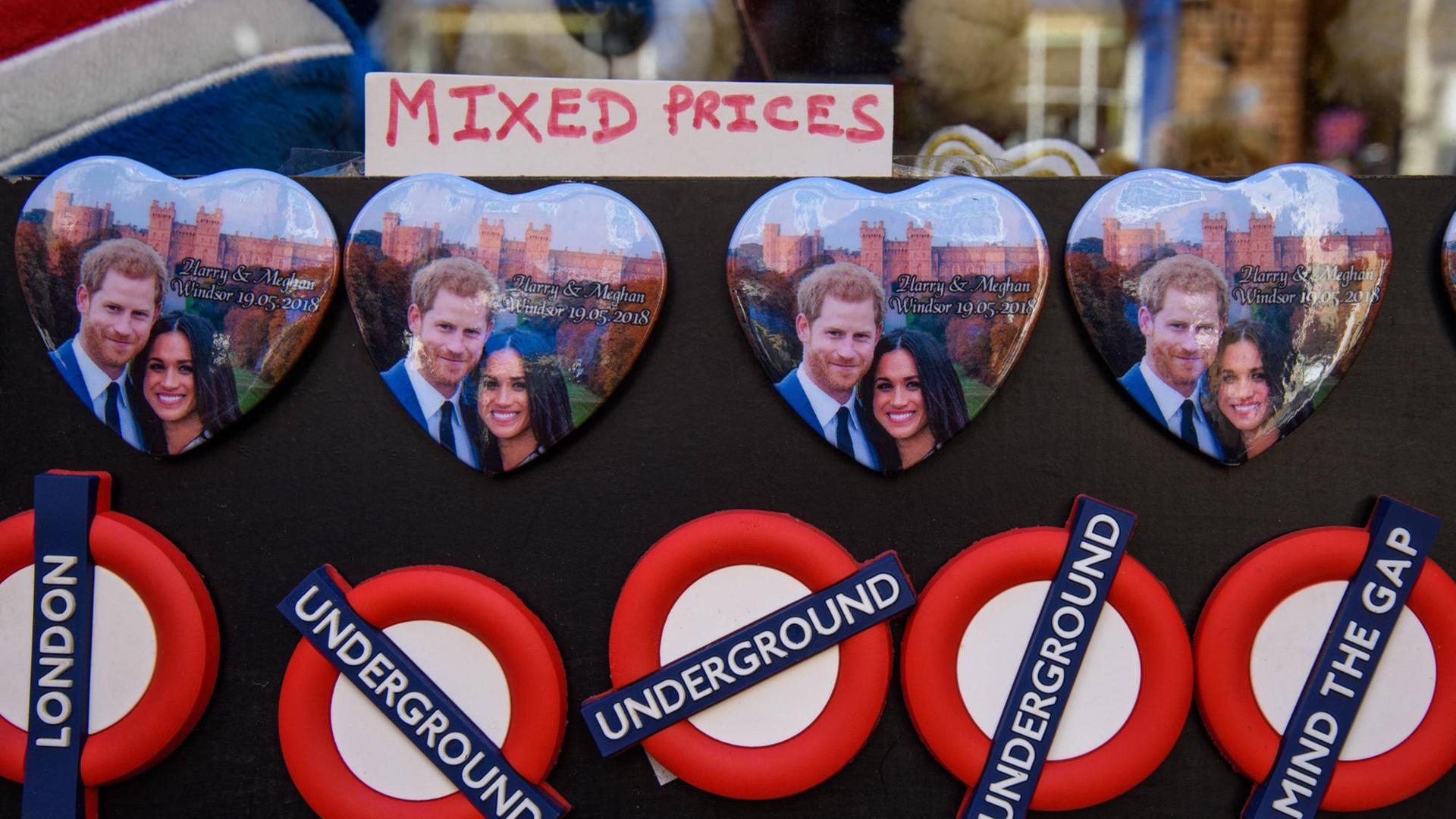 Magnete in Herzform mit dem Bild von Meghan Markle und Prinz Harry. Darunter Magnete mit dem Logo der Londoner U-Bahn.