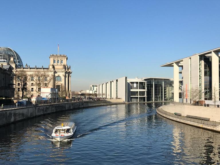 Ein weißer Dampfer fährt auf der Spree durch das Regierungsviertel von Berlin. Foto: M. C. Hurek | Verwendung weltweit