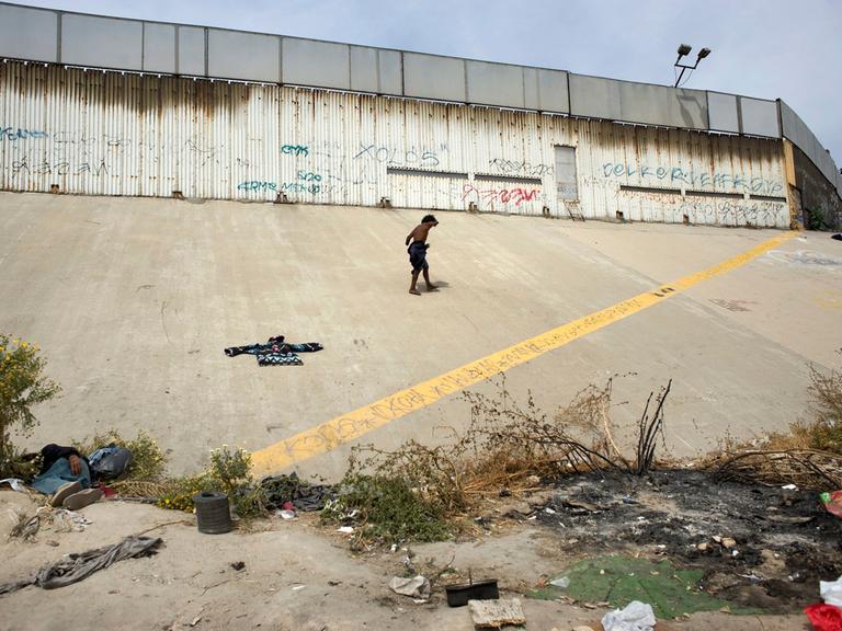 Ein obdachloser Migrant vor der US-Mexikanischen Grenze in Tijuana, Mexiko.
