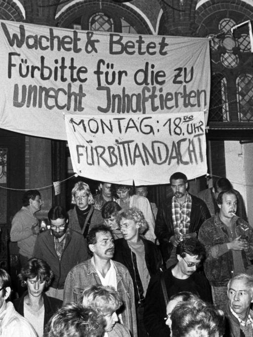 DDR-Bürger mit Transparenten vor der Gethsemanekirche 1989.