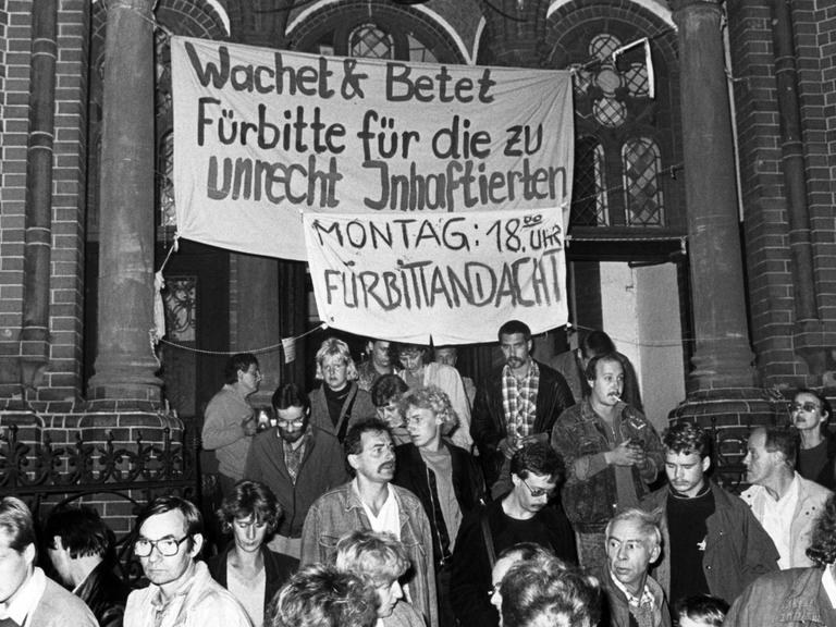 DDR-Bürger mit Transparenten vor der Gethsemanekirche 1989.