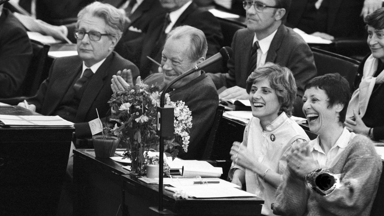 Einzug der Grünen in den Bundestag 1983. Marieluise Beck-Oberdorf, (r) und neben ihr Petra Kelly mit Blumen auf dem Pult während der konstituierenden Sitzung des Deutschen Bundestages in Bonn am 29.03.1983. Neben ihnen die SPD Politiker Willy Brandt.