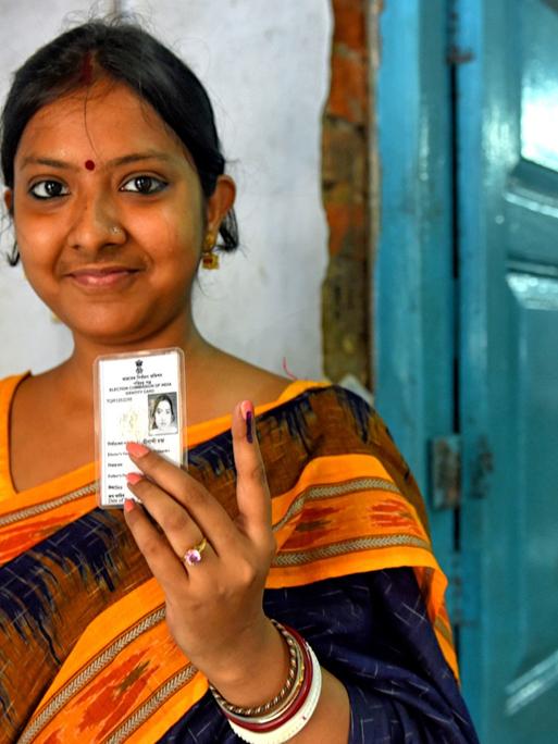 Eine junge Frau zeigt nach ihrer Stimmabgabe am 6.5.2019 in Barakpur, Westbengalen, ihren mit Tinte markierten Finger.