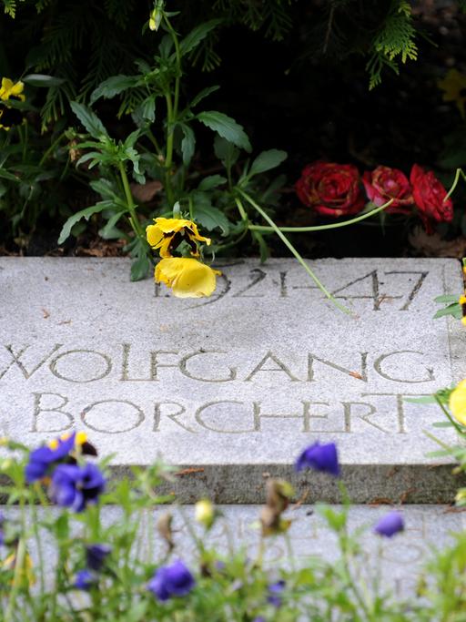 Blumen liegen auf dem Grab des Schriftstellers Wolfgang Borchert auf dem Friedhof Ohlsdorf in Hamburg.