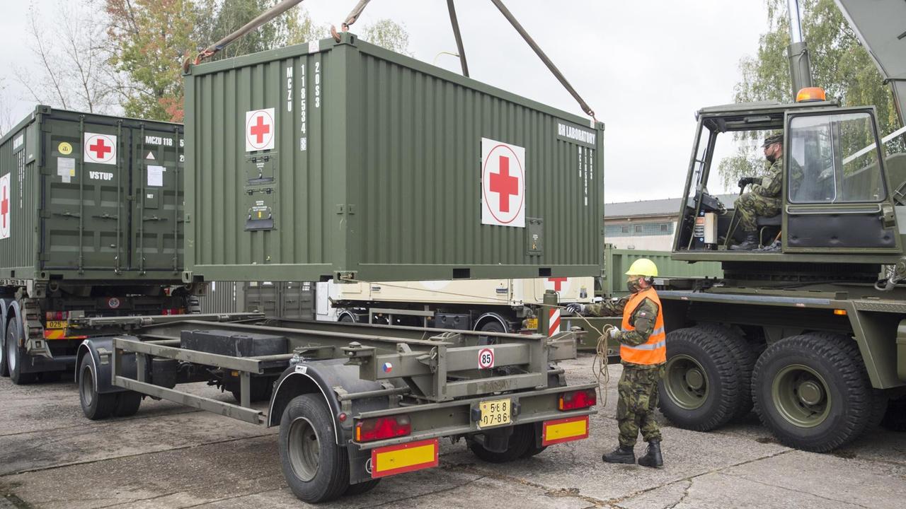 Ein Container mit medizinischem Gerät wird auf den Anhänger eines LKWs geladen. 