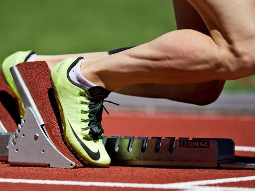 Eine Athletin steht im Startblock für einen 400 Meter Hürdenlauf.