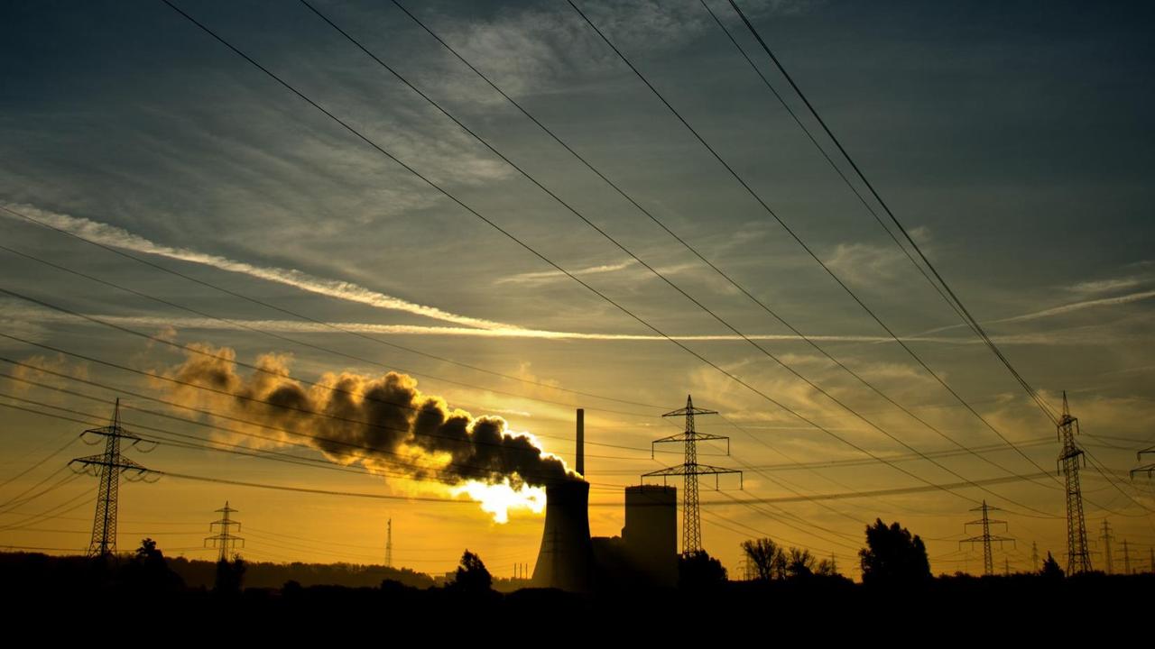 Die aufgehende Sonne taucht am 27.10.2014 den Himmel hinter dem Kohlekraftwerk Mehrum in Hohenhameln im Landkreis Peine (Niedersachsen) in warmes Licht.