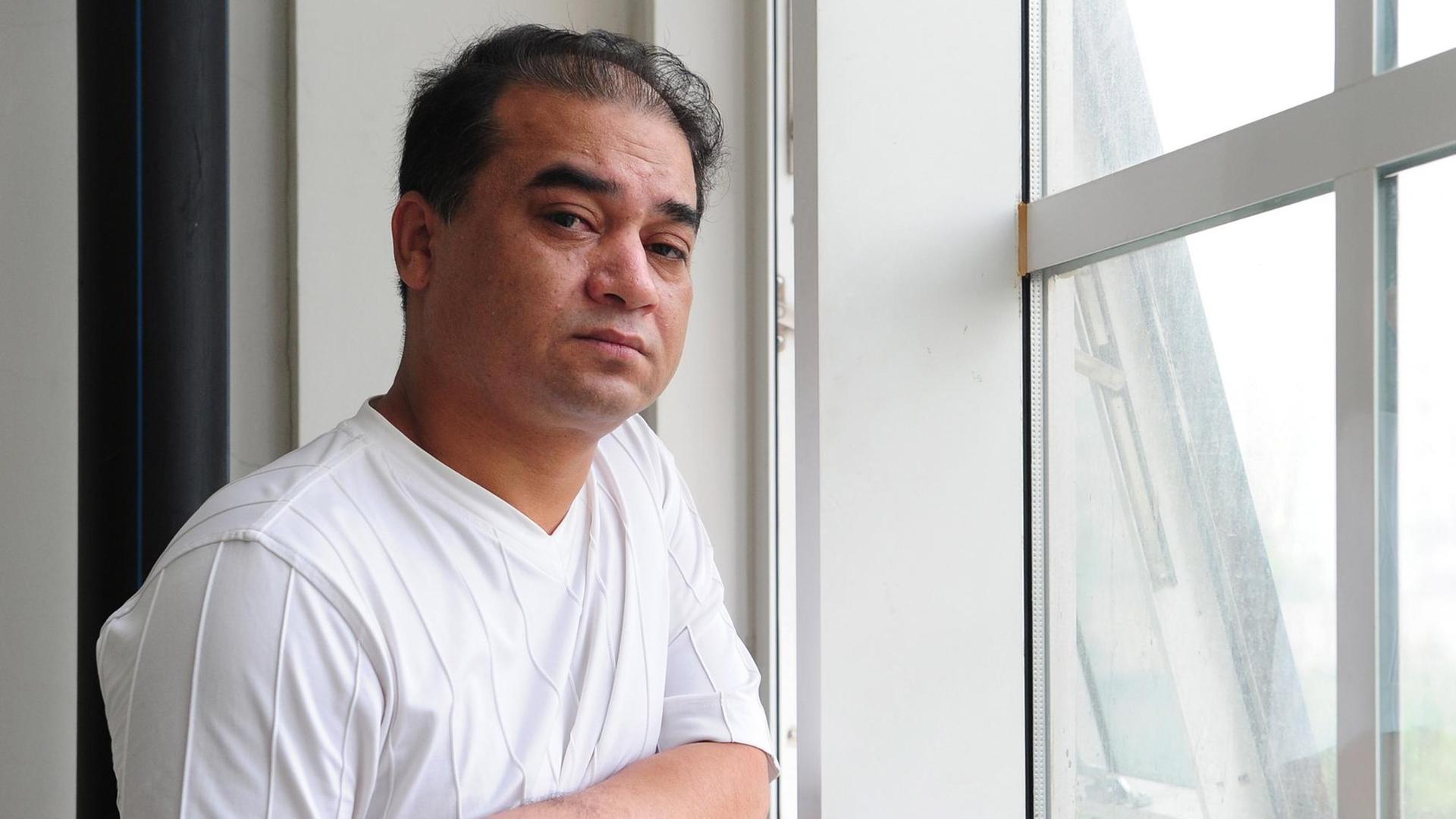 Der chinesischen Wissenschaftler Ilham Tohti steht vor einem Hörsaal.