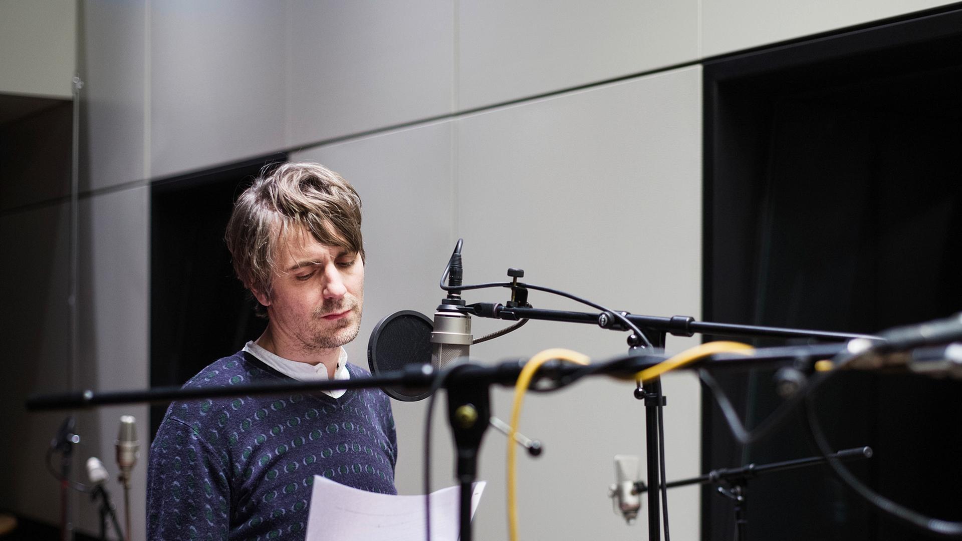 Der Schauspieler Jens Harzer steht im Studio am Mikrofon.