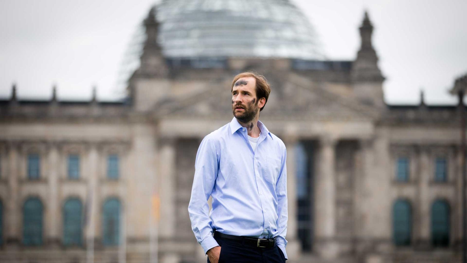 Mit beschmiertem Gesicht posiert Philipp Ruch vom "Zentrum für Politische Schönheit" am 08.08.2012 vor dem Reichstag in Berlin für den Fotografen.