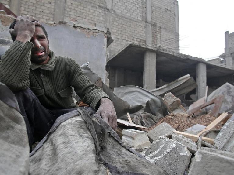 Ein Syrer sitzt am 5. Februar 2018 klagend auf den Mauern seines durch Luftangriffe zerstörten Hauses in der Region Ost-Ghuta nicht weit der Hauptstadt Damaskus.