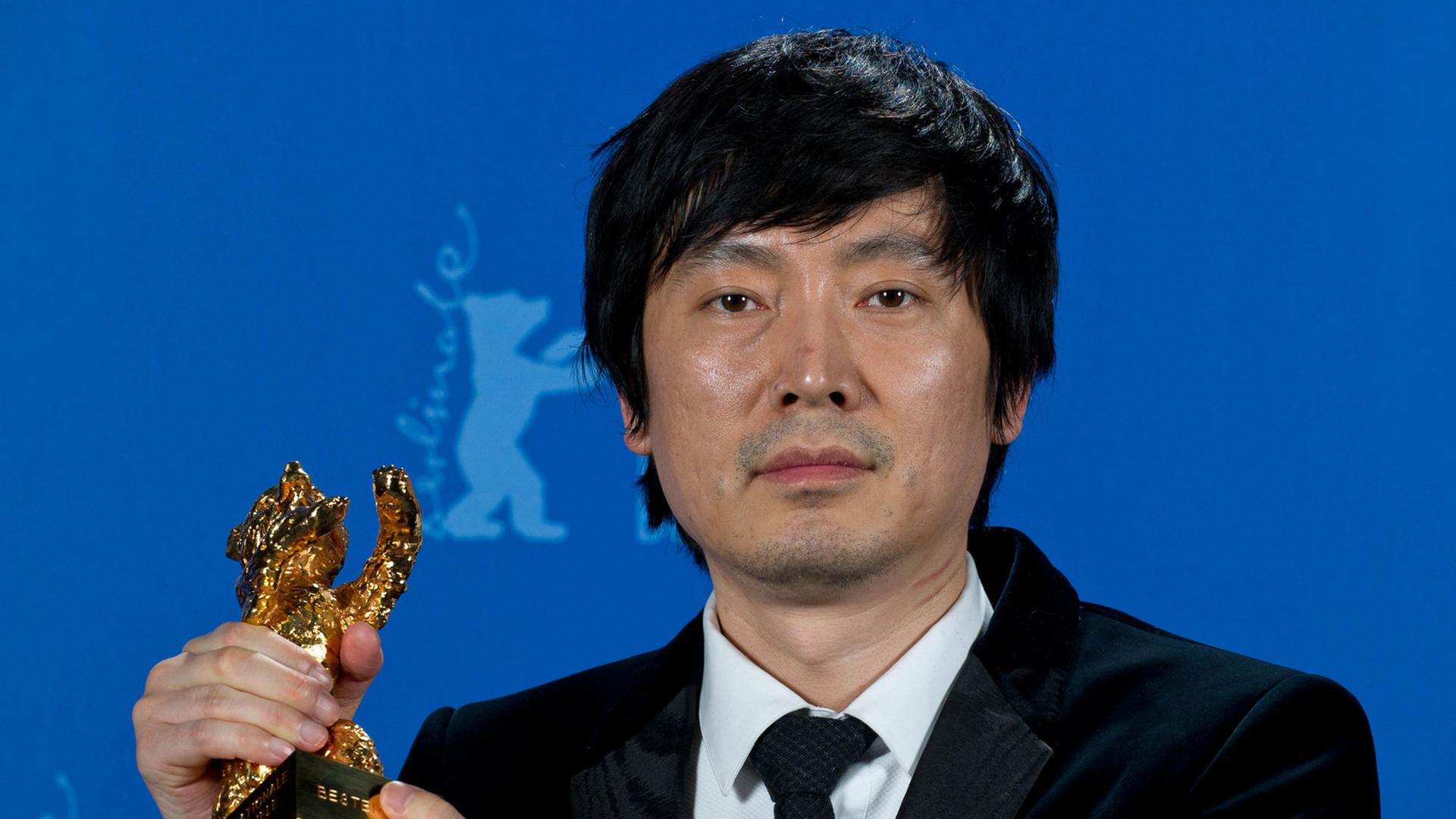 Diao Yinan, der Regisseur des Siegerfilms "Bai Ri Yan Huo (Schwarze Kohle, dünnes Eis)", posiert während der 64. Internationalen Filmfestspiele in Berlin mit dem Goldenen Bären.