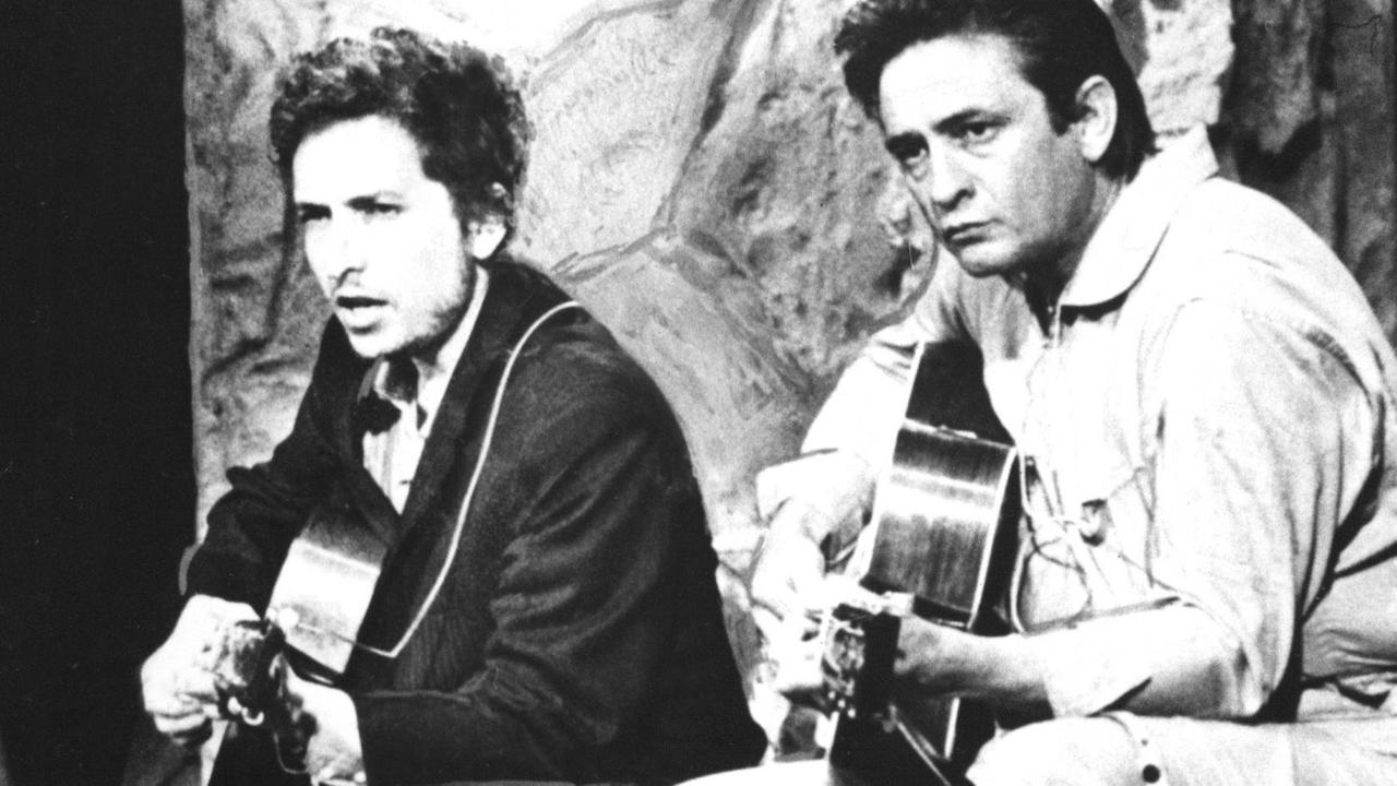 Johnny Cash und Bob Dylan spielen auf ihren Gitarren zusammen.