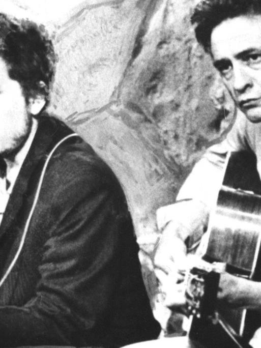 Johnny Cash und Bob Dylan spielen auf ihren Gitarren zusammen.
