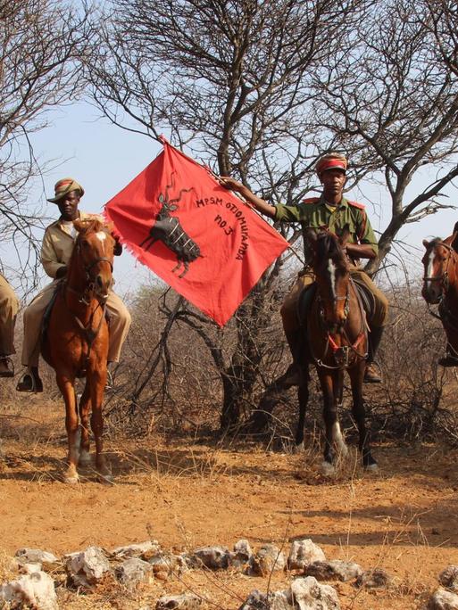 Menschen auf Pferden mit Flaggen: Nachkommen der Herero gedenken der Opfer des Völkermordes durch die Deutschen.