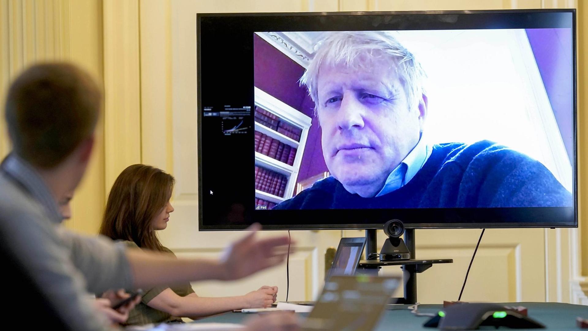HANDOUT - 28.03.2020, Großbritannien, London: Boris Johnson auf einem Bildschirm während einer Videoschalte aus der häuslichen Quarantäne Foto: Andrew Parsons/10 Downing Street/dpa