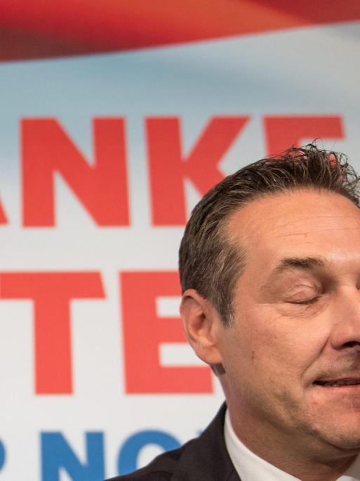 Heinz Christian Strache von der FPÖ reibt sich die Augen vor einem Plakat "Danke, Österreich"