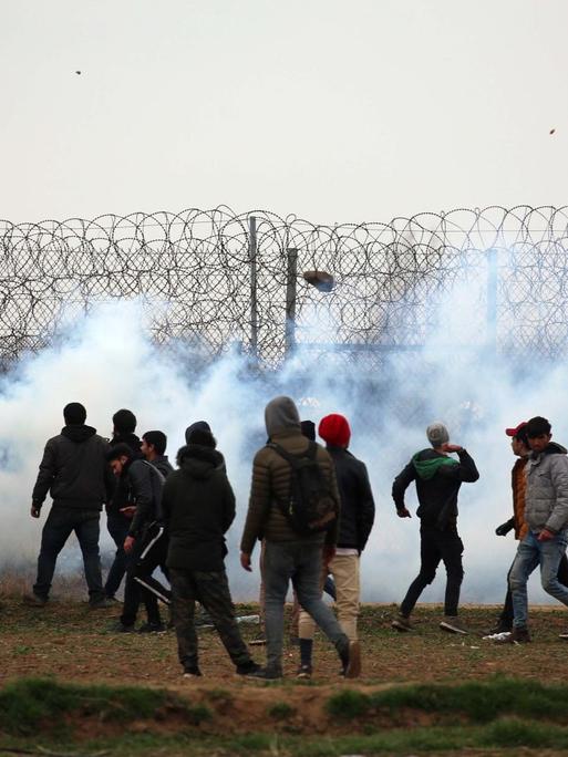 Menschen stehen an der griechisch-türkischen Grenze, an der Tränengas eingesetzt wird